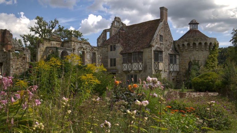 The old castle at Scotney with late summer flowers in the foreground